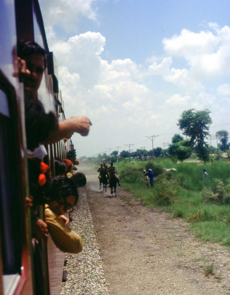 Soldiers on horseback gallop alongside the train, slowly overtaking