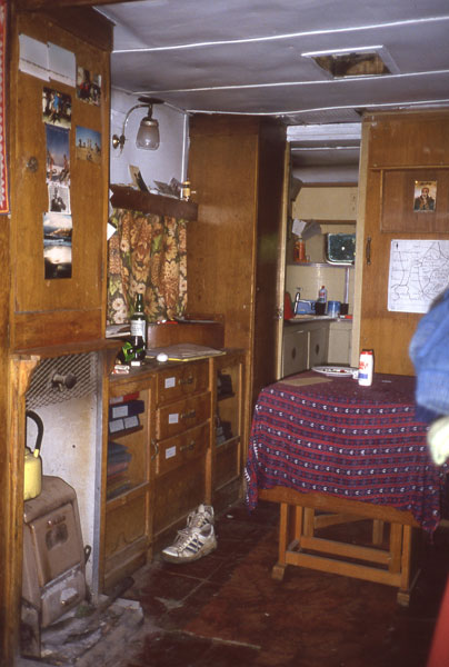 The first Dunshay caravan, showing the stove, a gas lamp, the distant kitchen, the decrepit ceiling and the wood partition (right) which folded down into a bed.