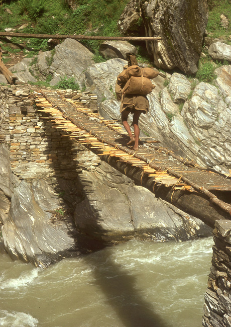 A shepherd crosses the Pindar river heading for alpine pasture to take over tending the family flock.