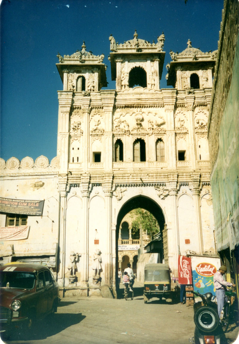 The gateway into Bhuj's palace sector before the 2001 earthquake . Frock-coated, tricorn-hatted Dutch figures are carved beside the archway.