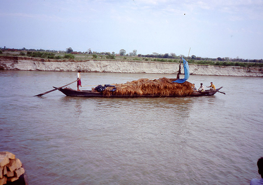 A loaded boat moves through the Bengal delta. It probably carries jute, a primary export from Bangladesh